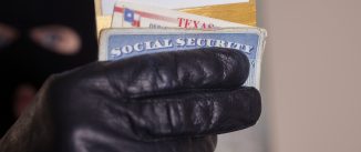 Masked theif steals a victim's identification cards.